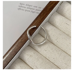 Macro view of minimalist irregular S925 sterling silver liquid ring in a jewelry box