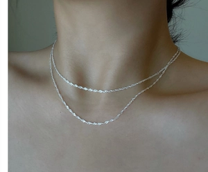 Detail shot of a double-layered S925 sterling silver water-ripple chain on a collarbone