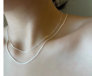Close-up of double-layer S925 sterling silver chain necklace on model collarbone