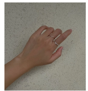 Bague incurvée en argent S925 et anneau large poli portés sur la main