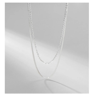 Detail of layered S925 sterling silver snake and cable chains with a silky satin finish