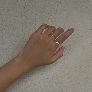 Détail d'un ensemble de bagues en argent S925 aux lignes courbées pour un look minimaliste