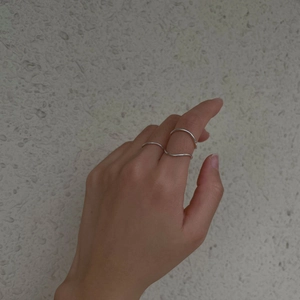 Vue macro d'une bague double couche incurvée en argent sterling S925 poli sur un doigt