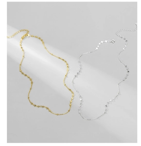 Macro shot of minimalist gold and silver collar necklaces with lobster clasp and chain links