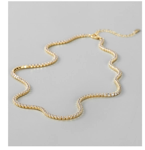 Detailansicht einer goldenen Tennis-Halskette mit funkelnden Zirkonia-Steinen im Pavé-Stil