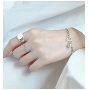 Minimalist S925 sterling silver ring set and ball charm bracelet on textured white fabric