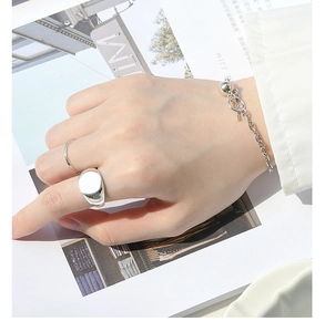 Macro detail of glossy S925 silver geometric ring and matching pig nose chain bracelet