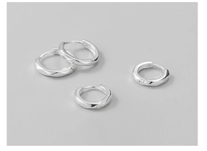 Macro detail of S925 sterling silver hoop earrings with geometric faceted design