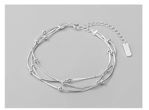 Makro-Detail des S925 Sterlingsilber dreischichtigen Schlangenarmbands mit polierten Perlen