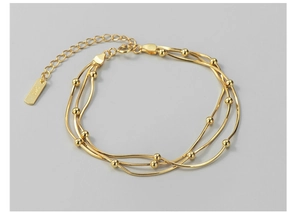 Makroaufnahme des S925-Stempels an einem mehrlagigen goldfarbenen Schlangenkettenarmband