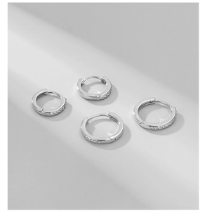 Gros plan détaillé de quatre créoles en argent sterling S925 avec zircons incrustés