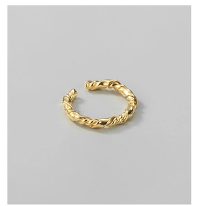 Macro detail of gold twisted rope ring featuring a polished metallic spiral texture
