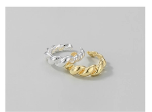 Detailed view of gold and silver twisted rope open rings with a polished metal finish