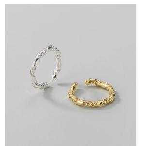 Detail of intertwined gold and silver S925 sterling silver rings with twisted rope design