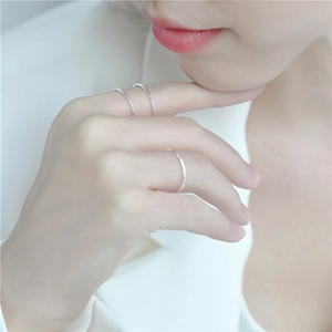 Three thin 925 sterling silver rings with hammered foil texture worn by a model