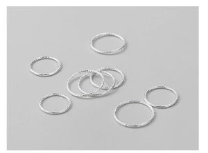 Macro detail of 925 sterling silver rings with hammered tin foil texture and sleek finish