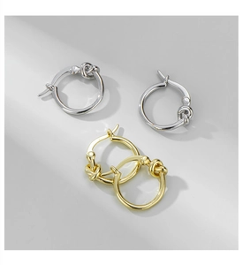 Detailed view of gold and silver knot hoop earrings with a minimalist twisted design