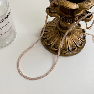 Detail of rose gold mesh necklace with tiny zircons and adjustable tail chain