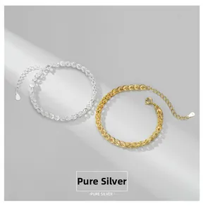 Macro shot of silver and gold woven bracelets featuring S925 tags and lobster clasps