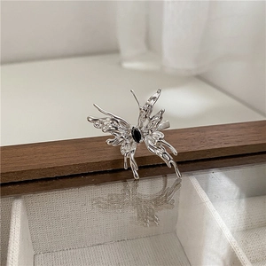 Close-up of S925 silver butterfly ring with black gemstone on a wooden jewelry box