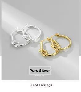 Détail de boucles d'oreilles nœud en argent sterling en finitions dorée et argentée