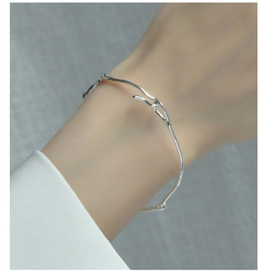 Gros plan d'un bracelet minimaliste en argent S925 irrégulier sur un poignet de modèle