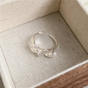 Macro shot of silver molten texture open ring inside a beige linen jewelry box
