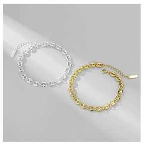 Detail of S925 sterling silver pig nose bracelets in gold and silver with lobster clasp