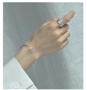 Détail de la bague en argent S925 texture lave et du bracelet branche minimaliste