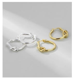 Vue macro de boucles d'oreilles en argent S925 avec design noué doré et argenté