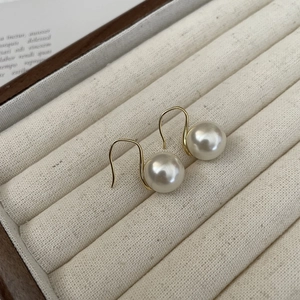 Close-up of elegant 18K gold-plated hook earrings with premium large white pearls
