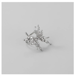 Macro shot of fluid liquid butterfly ring featuring polished chrome silver metal details