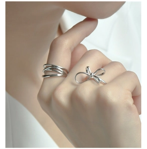 Nahaufnahme der S925 Sterlingsilber Schleife und mehrlagiger Ring am Finger