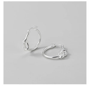 Détail des boucles d'oreilles en argent sterling S925 avec un design de noeud épuré