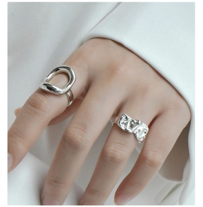 Detail of silver S925 rings with metallic crinkle texture and irregular hollow design