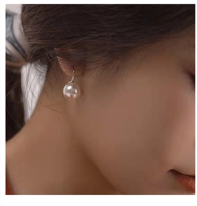 Close-up of S925 silver high heel drop earrings with white pearls on a female model
