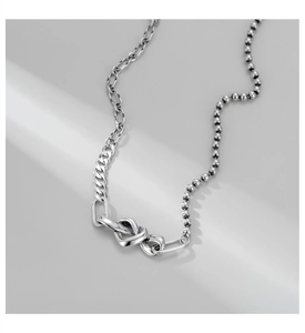 Détail du collier en argent S925 montrant les mailles mixtes et le pendentif nœud