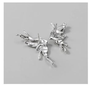 Dettaglio degli orecchini in argento S925 con design a farfalla in metallo liquido fuso