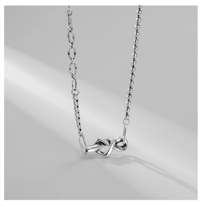 Détail du pendentif nœud de cœur en argent S925 avec double chaîne asymétrique élégante