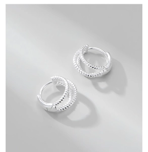 Macro detail of S925 sterling silver stamp on twisted double hoop earring design