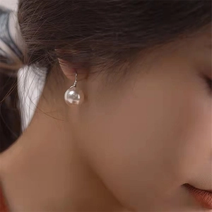 Elegant S925 silver high heel style earrings with round white pearls on female model