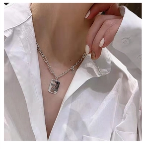 Detailed view of S925 sterling silver Luck pendant necklace on model neck with white shirt