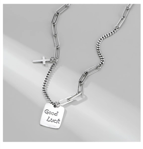 Detail of S925 silver necklace featuring a Luck square pendant and cross on a mix chain