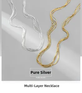 Close-up of a multilayer S925 pure silver chain necklace in gold and silver finishes