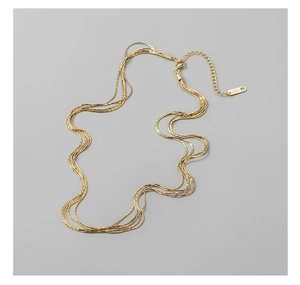 Macro detail of multilayered S925 sterling silver chain with secure lobster clasp and tag