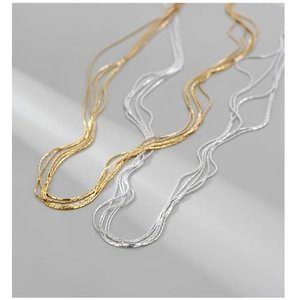 Detailed view of layered S925 sterling silver chain necklaces in gold and silver finishes
