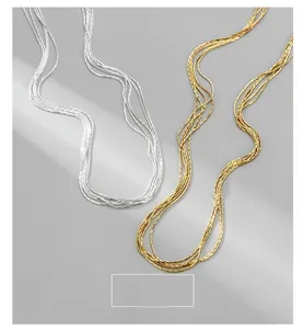 Detail of multi-strand 925 silver necklaces in gold and silver with layered texture