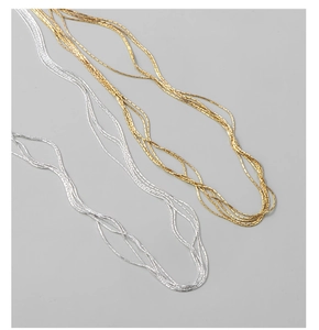Detail of multi-strand silver and gold necklaces showing fine metallic texture