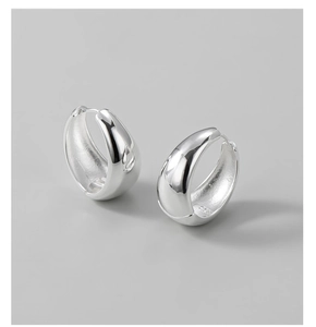 Macro shot of polished S925 sterling silver hoop earrings with high-shine metallic finish