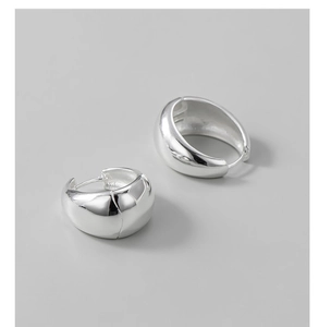 Detailed view of wide polished S925 sterling silver huggie hoop earrings with mirror finish